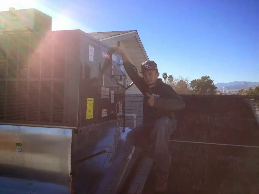 HVAC technician performing AC Tune-Up on a rooftop unit in Horsham